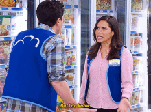 a woman wearing a blue vest that says lucia stands next to a man