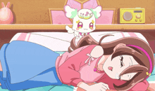 a girl in a pink shirt is laying on a bed with a stuffed animal
