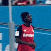 a soccer player wearing a red banner jersey