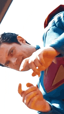 a close up of a man in a superman costume giving a thumbs up