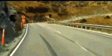 a car is driving down a highway with a no u turn sign on the side of the road