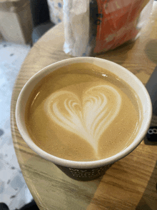 a cup of coffee has a heart shaped latte art
