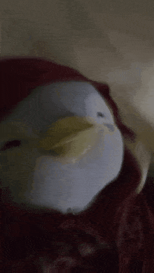 a stuffed animal is laying on a bed with a red blanket