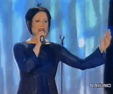 a woman singing into a microphone with the word raiuno on the bottom right