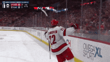 a hockey player with the number 12 on his jersey is celebrating