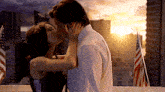 a man and a woman kissing in front of a city skyline