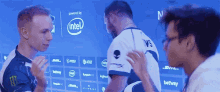 two men standing in front of a wall that says intel on it