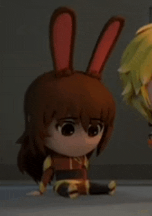 a close up of a doll with bunny ears sitting on the floor next to another doll .