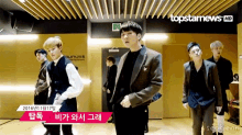 a group of men are dancing in front of a sign that reads topstarnews
