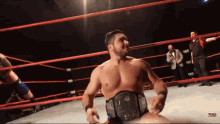 a man in a wrestling ring with a belt that says tna