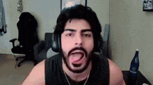 a man with a beard is making a funny face while wearing headphones .