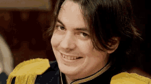 a close up of a man wearing a blue and yellow uniform smiling .