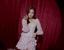 a woman in a plaid dress is making a middle finger gesture