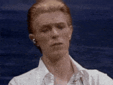 a man with red hair is wearing a white shirt