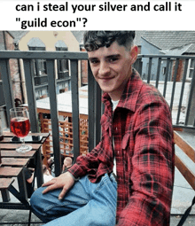 a man in a red plaid shirt is sitting on a balcony