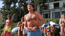 a man without a shirt is standing in front of a group of people