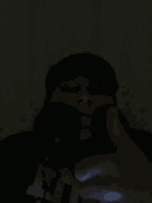 a man in a black shirt is holding a black object in his hand .