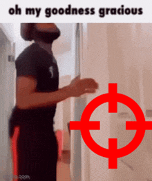 a man is standing in front of a door with a red target in the background