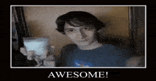 a young man is holding a glass of milk and a poster that says awesome !