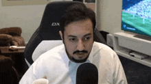 a man with a beard is sitting in a chair with a dx logo on it