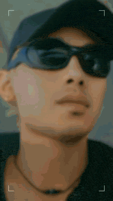 a blurry picture of a man wearing sunglasses and a black hat