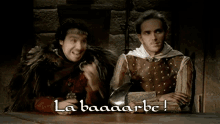 two men are sitting at a table with the words la baaaarbe written on the bottom