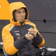 a man wearing a dell jacket is smoking a cigar