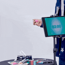 a man stands in front of a screen that says 2:00 on it