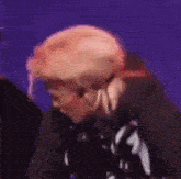 a close up of a person 's head with a skull on it against a purple background .
