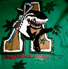 a green shirt with a shark holding a lacrosse stick