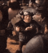 a cartoon character wearing a horned helmet is standing in a crowd .