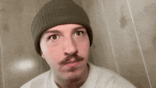 a man with a mustache wearing a beanie