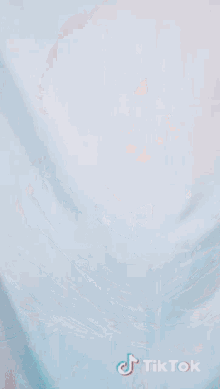 a girl with green hair is wrapped in a blanket and has tiktok written on the bottom right corner