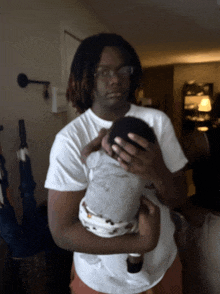 a man is holding a baby in his arms in a living room
