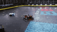 two robots are fighting in a stadium with a sign that says battlebots on it
