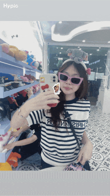 a woman wearing sunglasses and a headband with an elephant on it takes a picture of herself