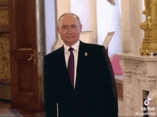 a man in a suit and tie is standing in a hallway with a tik tok watermark