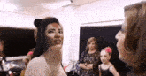 a woman with a mask on her face looks at another woman .