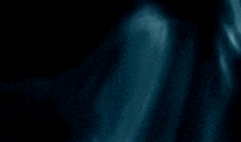 a blurry picture of a person 's face in the dark with a blue background .