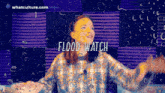 a woman stands in front of a purple wall with the words " flood watch " above her