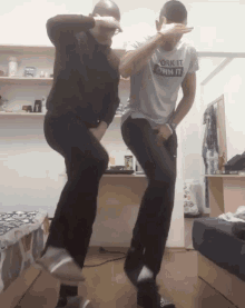 a man wearing a shirt that says ask it own it is dancing with another man