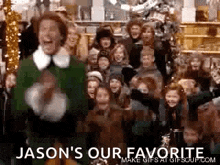 a man in a green elf costume is standing in front of a large group of people .