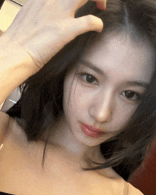 a woman is taking a selfie with her hand on her forehead
