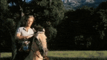 a man standing next to a horse in a field