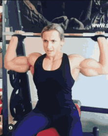a woman is sitting on a bench holding a barbell over her head .