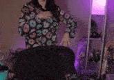 a woman is standing in front of a microphone wearing a donut print sweater