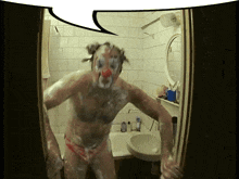 a man with a clown mask on his face stands in a bathroom