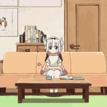 a little girl with horns is sitting on a couch reading a book
