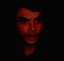a close up of a man 's face with his mouth open making a scary face .