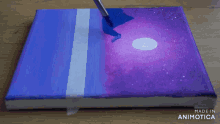 a painting is being painted on a canvas with the words made in animotica below it